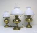 Three brass lamps with white shades