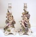 Pair of figural porcelain candlesticks with cupids