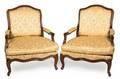 A Pair of Louis XV Style Carved Walnut Fauteuils