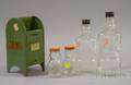 AllAmerican Painted Metal Mailbox Bank and Four Colorless Molded Figural Glass Bottle Banks