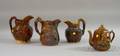 Benningtontype Glazed Molded Stoneware Teapot and Three Houndhandled Pitchers