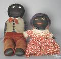 Two cloth black dolls with stitched features and stuffed bodies